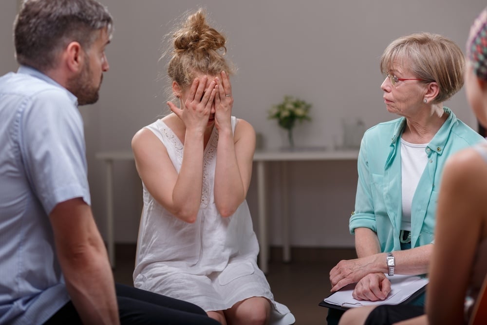 Photo of depressed female during session of support group